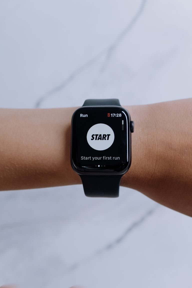 Close-up of a smartwatch showing a running app on a marble background.